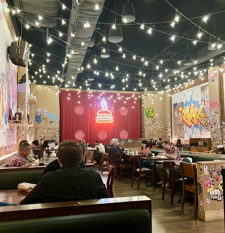 interior of burger joint with a red sign featuring a burger on the back wall in midtown nyc