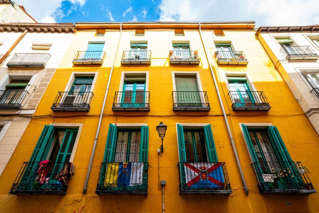 Colorful yellow building with green shutters in La Latina Madrid Spain