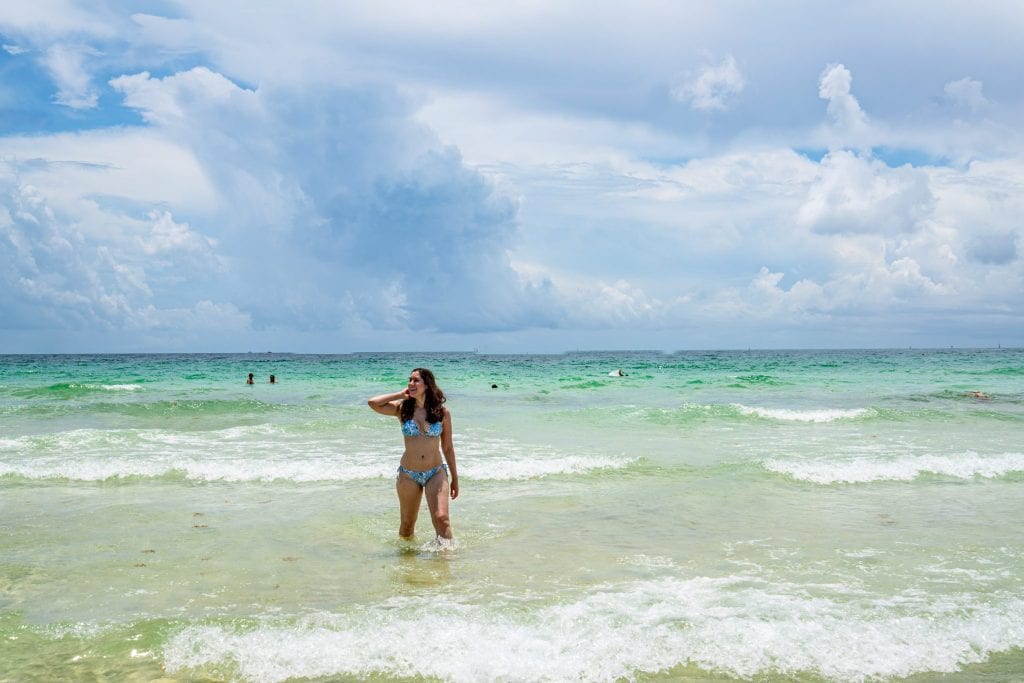 Kate in a blue bikini walking toward the camera. She's in the ocean on South Beach.
