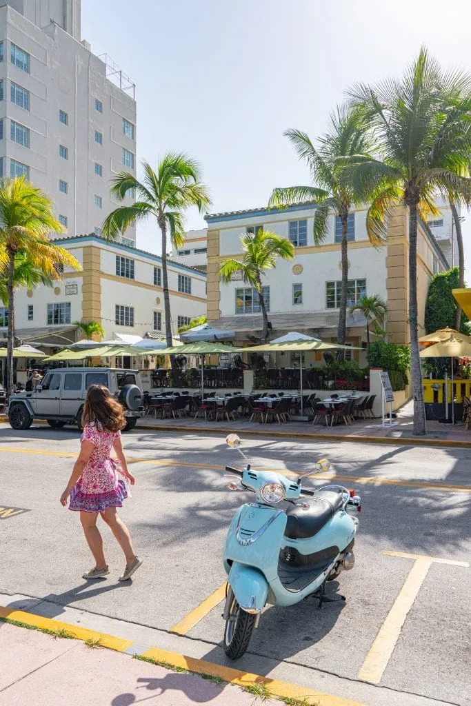 Kate in a pink dress next to a blue Vespa on Ocean Avenue.