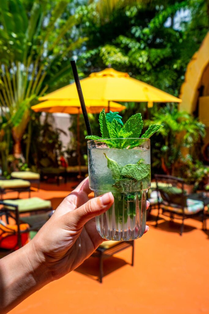 mojito being held in front of a yellow umbrella in miami fl