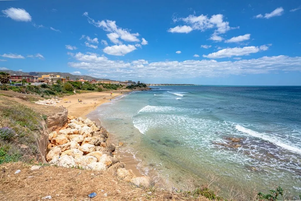 empty beach as seen on a sunny day in avola sicily with sea on the right side of the photo, as seen as part of a sicily road trip