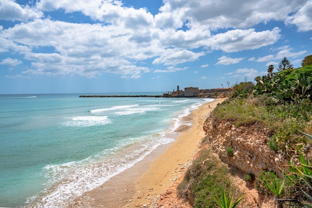 Long stretch of empty beach in Avola Sicily--one of these Italy fun facts is that Sicilian is still spoken widely, and is a completely separate language from Italian