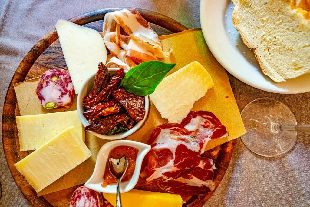 Prosciutto and cheese platter with bread as seen from above--be sure to eat plenty of delicious food like this during your 10 days in Sicily!