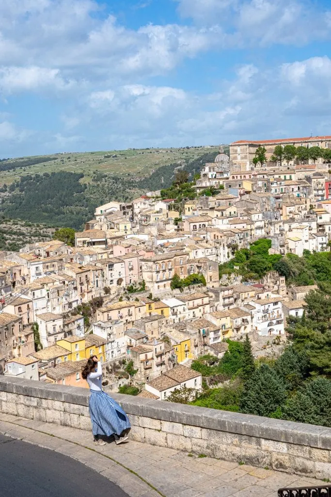 Kate Storm in a blue skirt overlooking Ragusa Ilba from Ragusa Superiore, one of the best views on this 10 days in Sicily itinerary