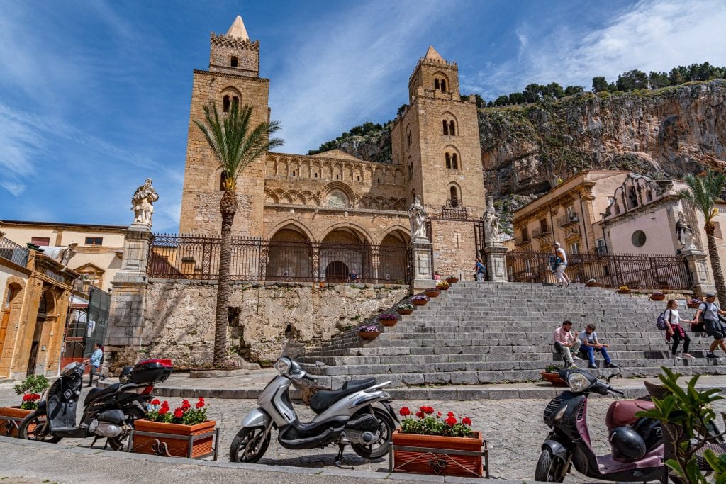 Cefalu Cathedral with a vespa parked in front of it, one of the best things to see on a Sicily road trip itinerary