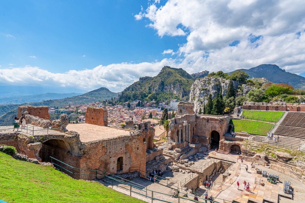 Photo of Taormina visible beyond part of the Greek Theatre.