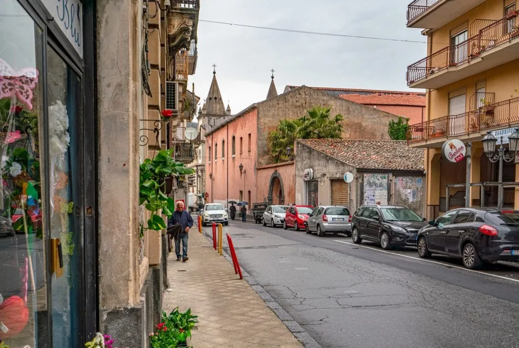 Quiet street in Francavilla Sicily on a rainy day with cars parked along the edge