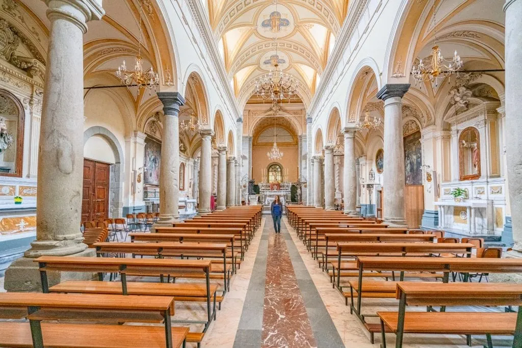 Kate Storm in a blue shirt standing in a church in Francavilla Sicily