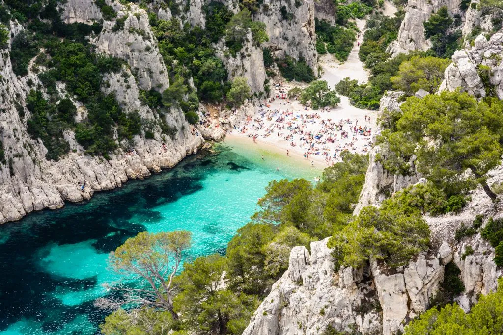 crowded beach at a french calanque as seen from above