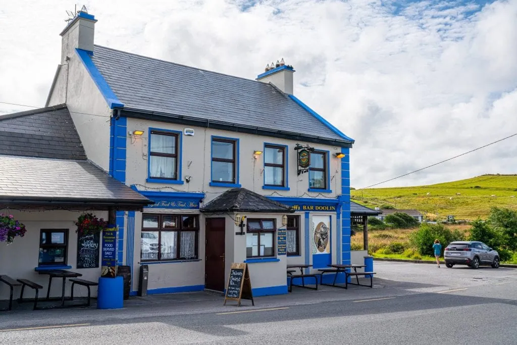  udvendig McDermott ' s Pub i Doolin. Bygningen er hvid med blå trim.