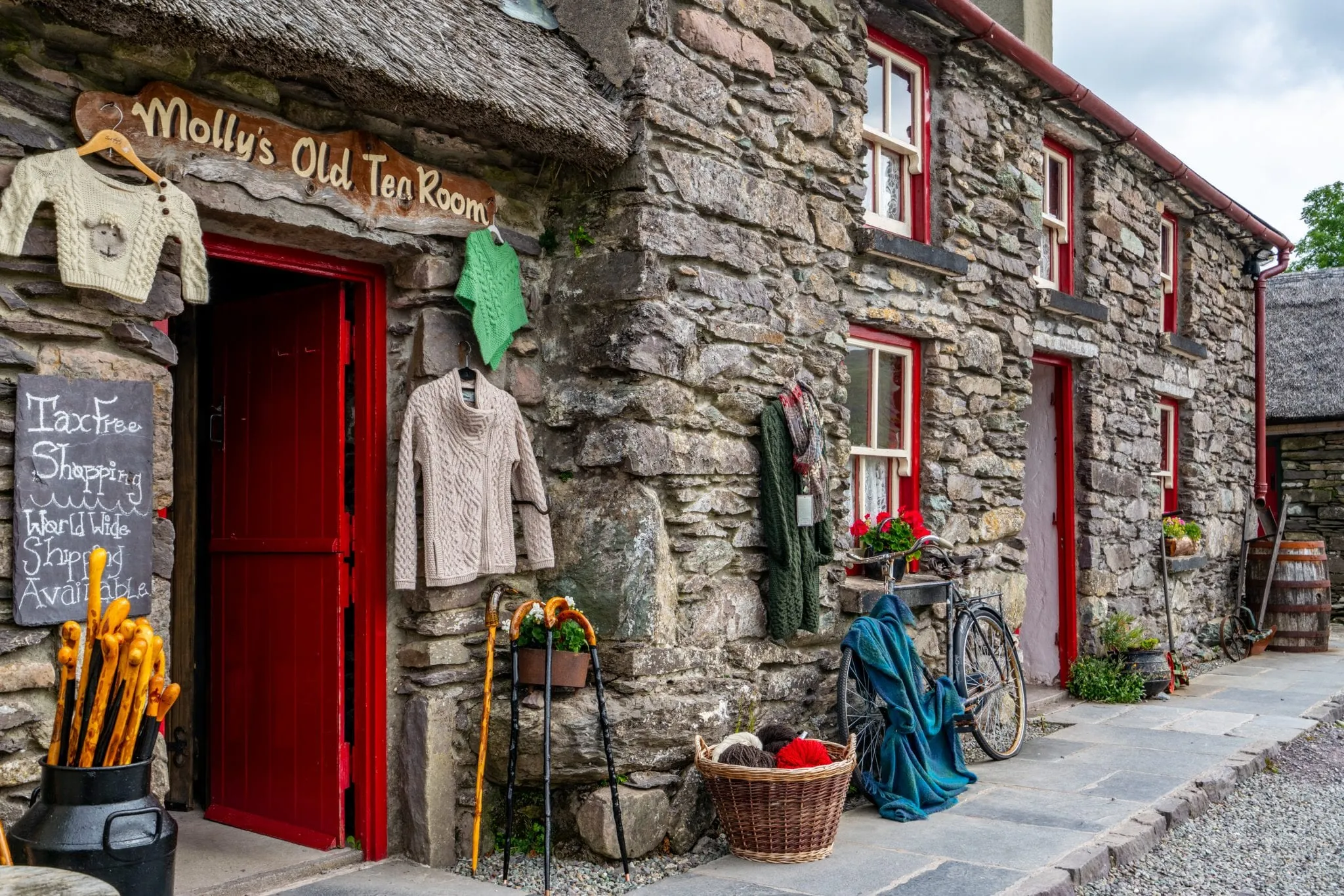 Souvenir shop in Ireland selling wool sweaters. The building is stone and red. If you want to buy wool in Ireland, don't overpack when deciding what to bring to Ireland.