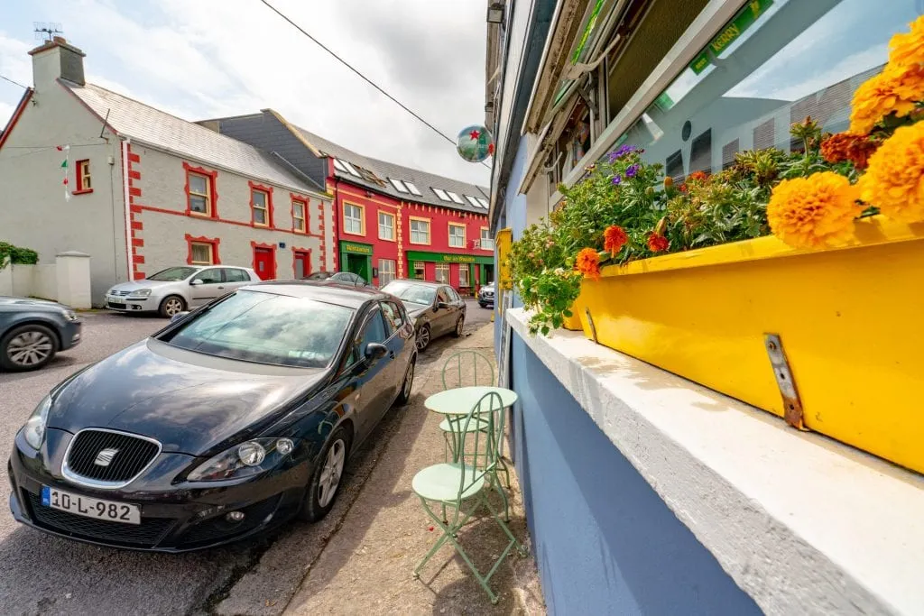 Street in small village along Slea Head Drive with a car parked on the edge of the street