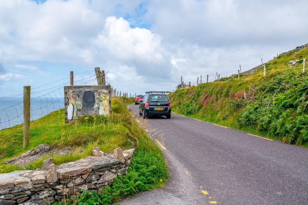 Small road along Slea Head Drive showing a car driving away
