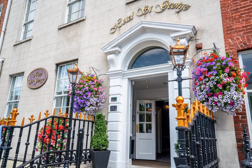 Entrance to Hotel St George in Dublin Ireland. There are flowers hanging on either side of the door