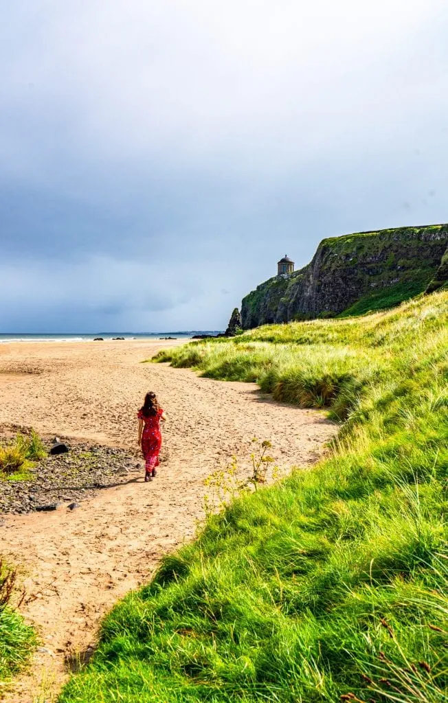 Kate Storm in a red dress on Downhill Beach in Northern Ireland, one of best things to see in Ireland off the beaten path