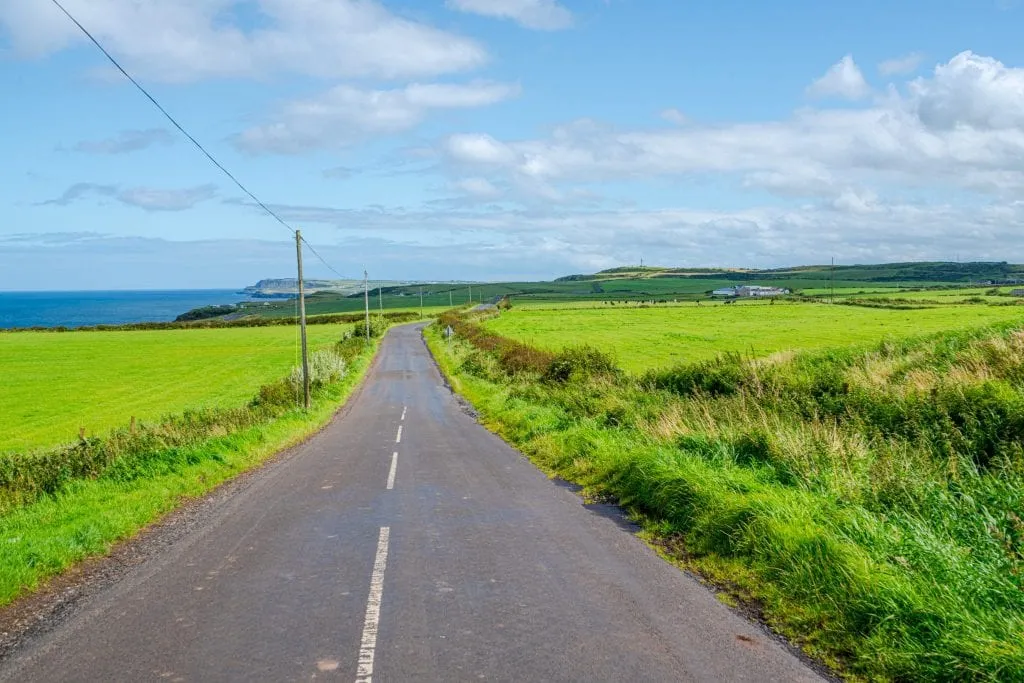 Open road in Northern Ireland with green fields on either side