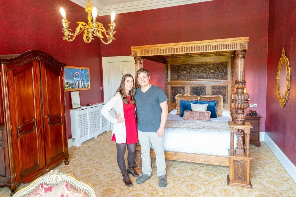 Kate Storm and Jeremy Storm sitting on a four posted bed in Belleek Castle Ireland