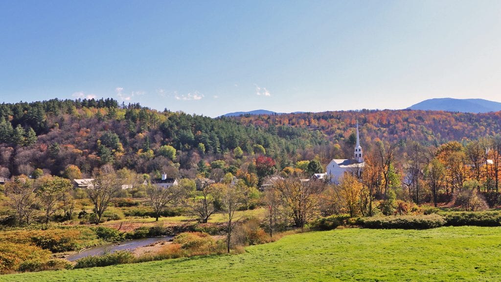 Stowe Vermont from above with fall colors on the trees and a white church on the right side of the photo