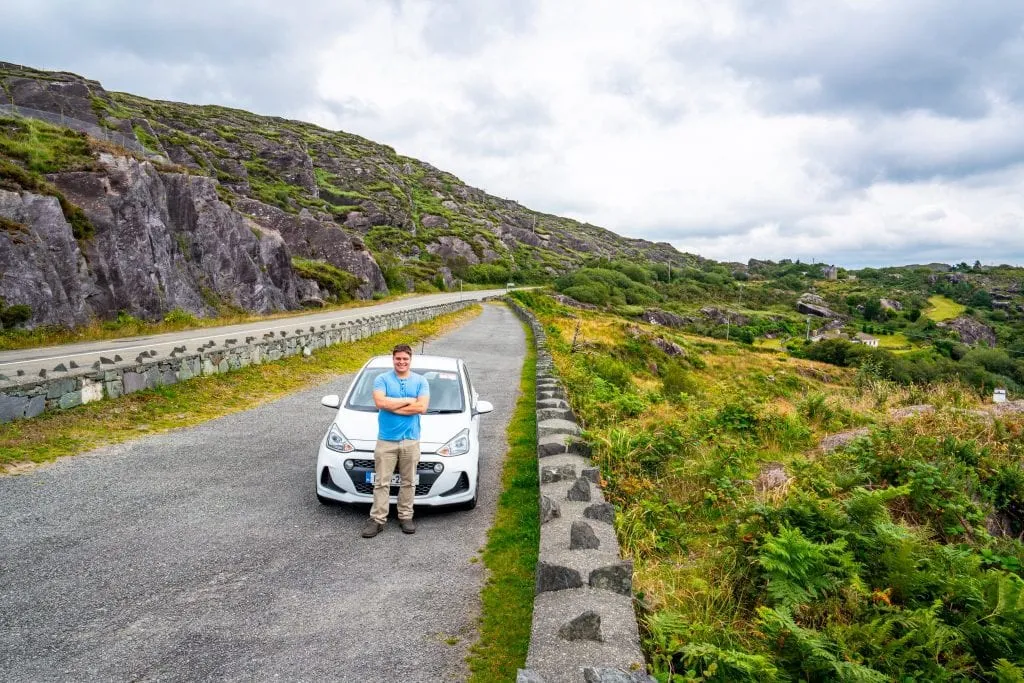 Jeremy Storm with a white rental car on the Ring of Beara during an Ireland road trip