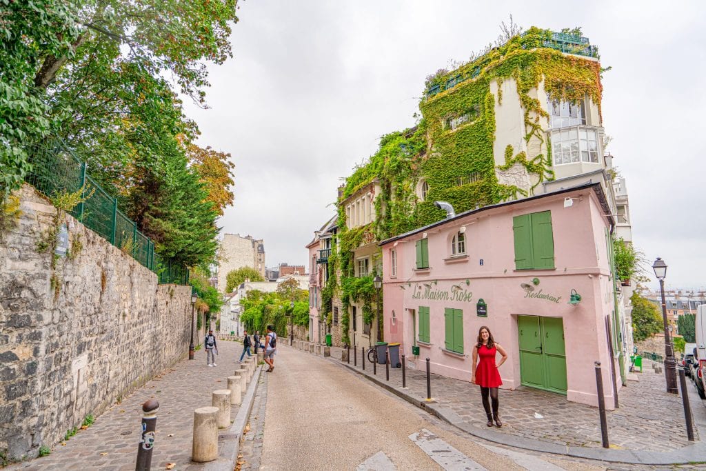 kate storm standing in front of la maison rose, a parisian bucket list sightseeing stop