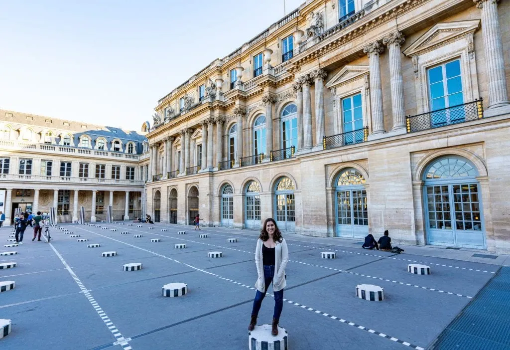 Kate Storm standing amongst the Colonnes de Buren, one of the best photo spots in Paris