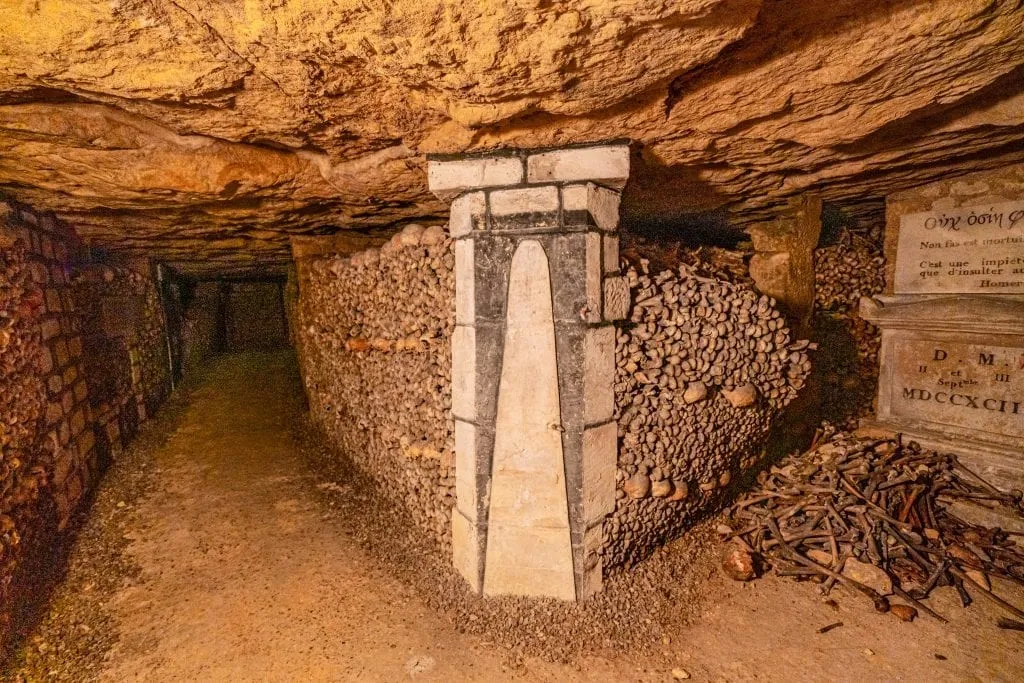 Corner in the Paris catacombs with bones spreading on either side