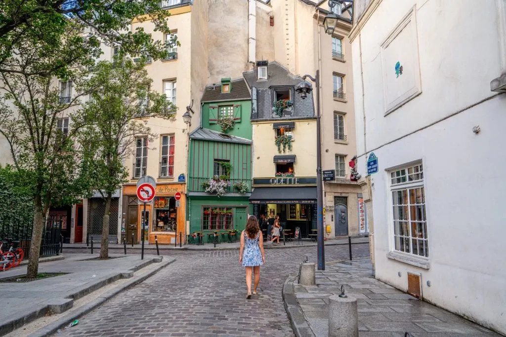 Kate Storm in a blue & white dress in front of Cafe Odette--consider coffee here during your one day in Paris!