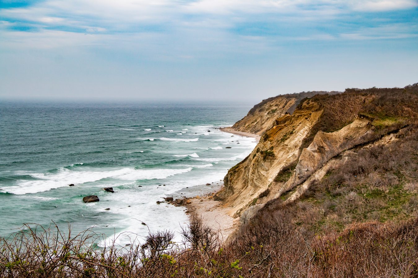 rocky cliffs along the coast of block island rhode island, one of the most unique places to go in new england