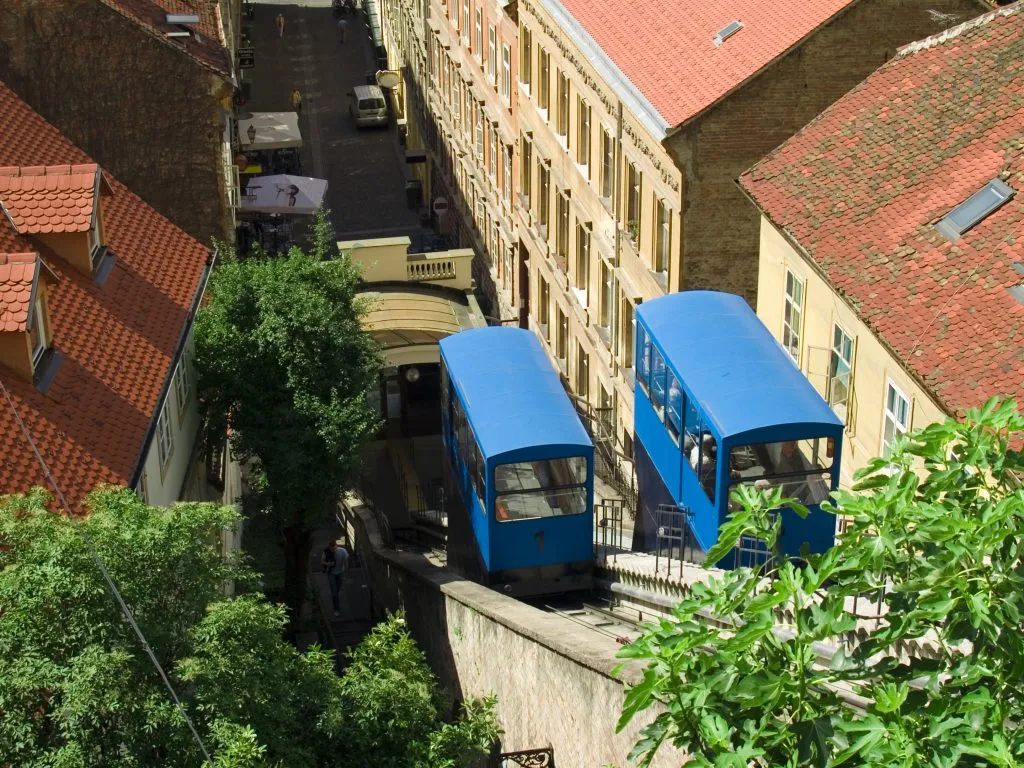 view of blue cars of zagreb funicular from above, one of the best things to do in zagreb croatia