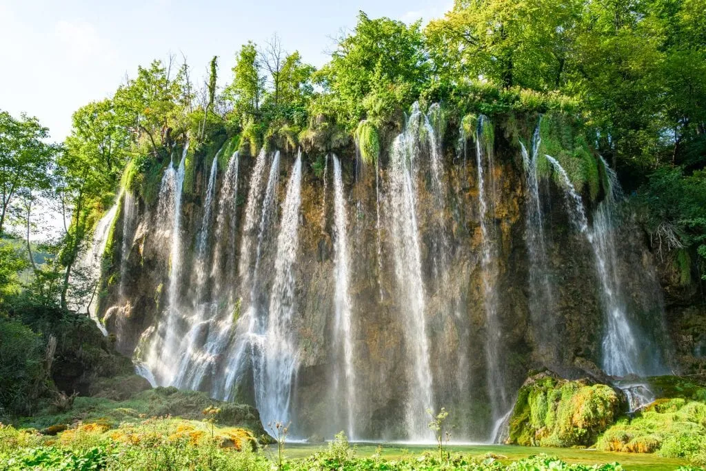 Large waterfall pouring over a broad surface in Plitvice Lakes Park