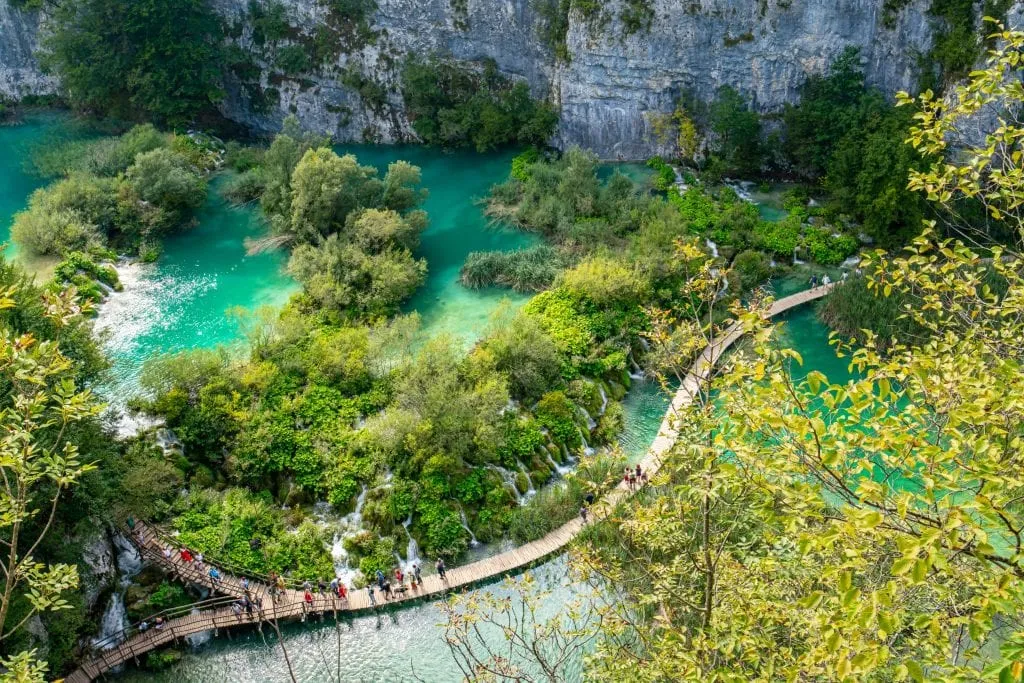 View of the ramps crossing Plitvice Lake National Park in Croatia with turquoise water on either side as seen from above