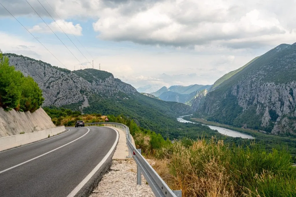 Empty, winding road in Croatia near Omis as seen on a cloudy day with a view of the forest in the background--views like this make a Croatia road trip special!