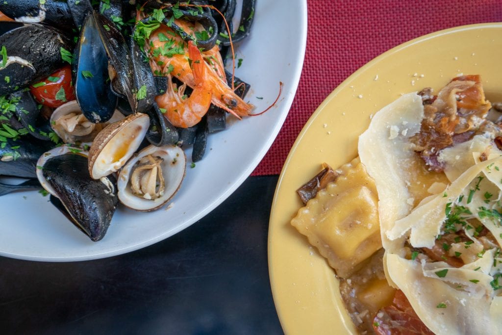 Photo from aboe with plate of mussels on the left and ravioli on the right, taken in Croatia