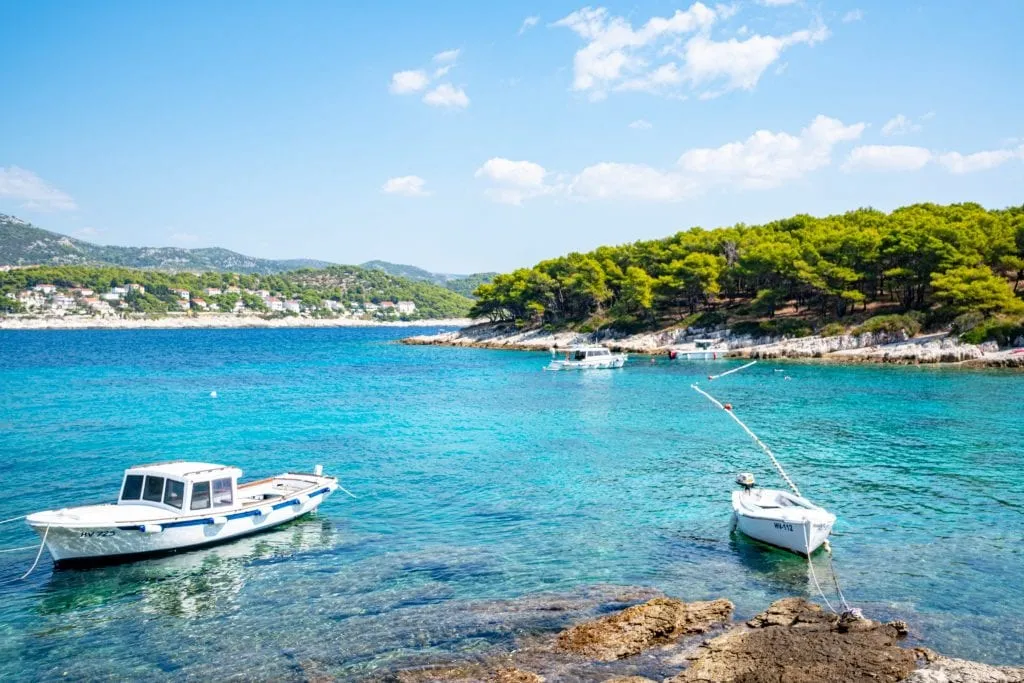 Small boats parked near a rocky shore on the Pakleni Islands, one of the best things to do in Hvar