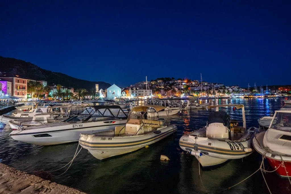 Photo of Hvar's harbor at night with boats in the foreground