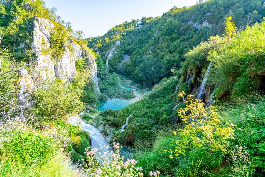 Several small waterfalls in Plitvice Lakes National Park surrounded by karst cliffs and pouring into turquoise lakes
