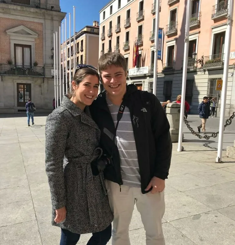 Kate Storm and Jeremy Storm standing in a square in Madrid Spain with a pink building behind them