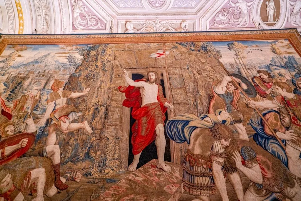 vatican tour today Tapestry with Jesus in the foreground in a red robe, as seen when visiting the Vatican Museums in Rome
