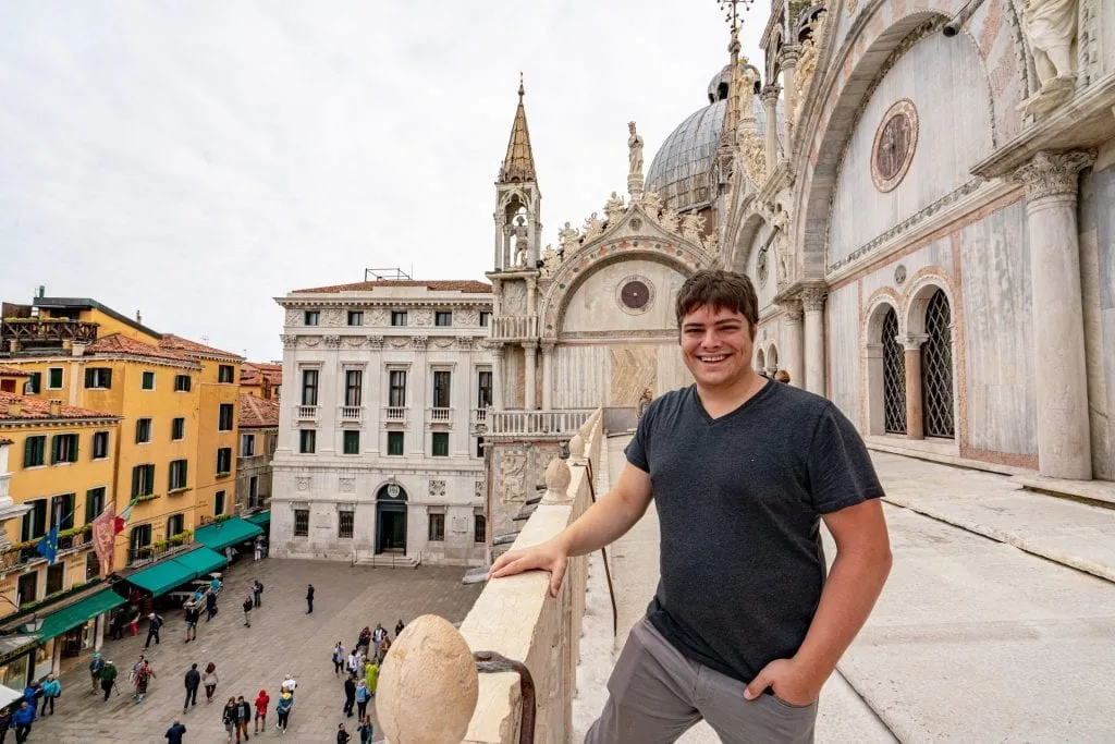 Jeremy Storm wearing a gray t shirt on the roof of St. Mark's Basilica--definitely worth visiting this spot during your day trip to Venice from Florence!