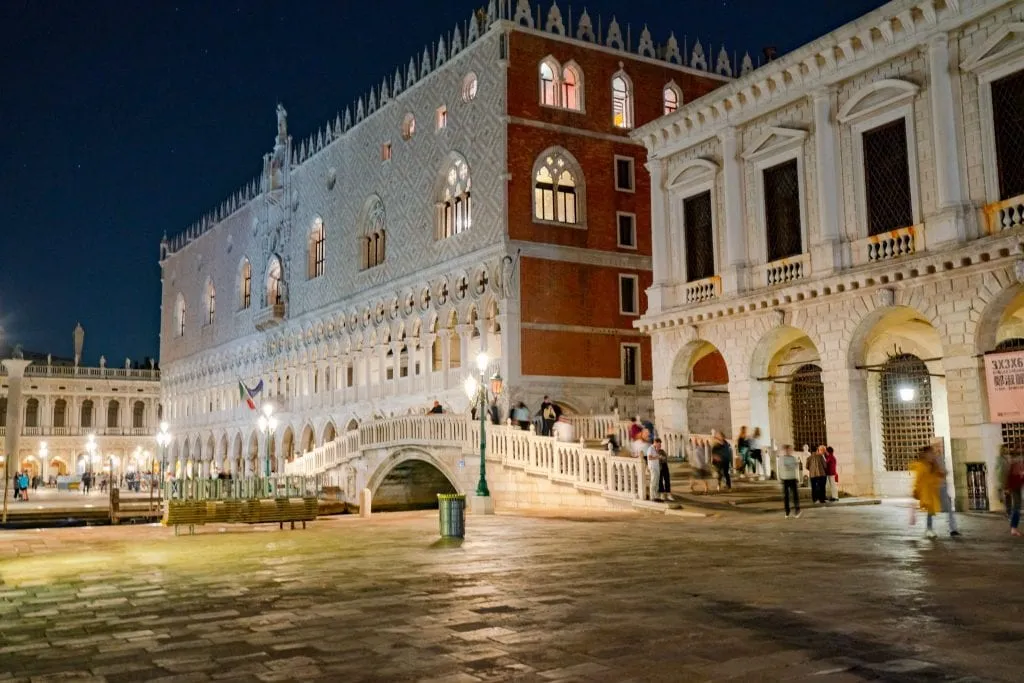 Photo of the Doge's Palace at night taken from the Riva degli Schiavoni--touring the palace after hours is one of the best things to do in Venice at night!