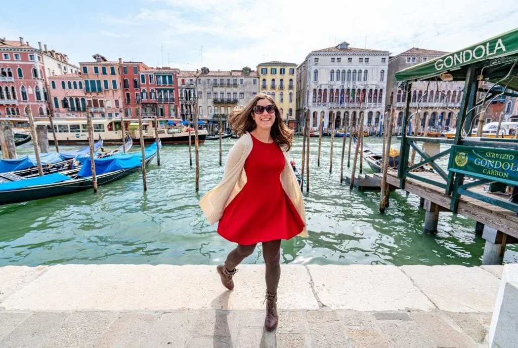 Kate Storm in a red dress spinning in front of the Grand Canal in Venice