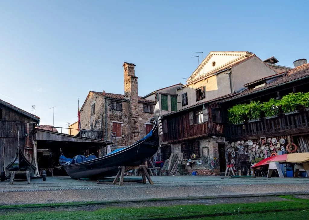 Photo of a gondola shop in Venice with a gondola on risers out front to be repaired