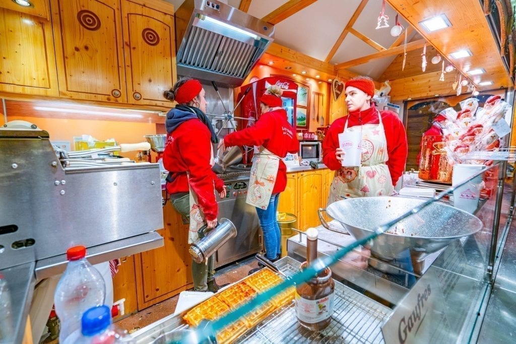 people preparing christmas market food in a stall in colmar france