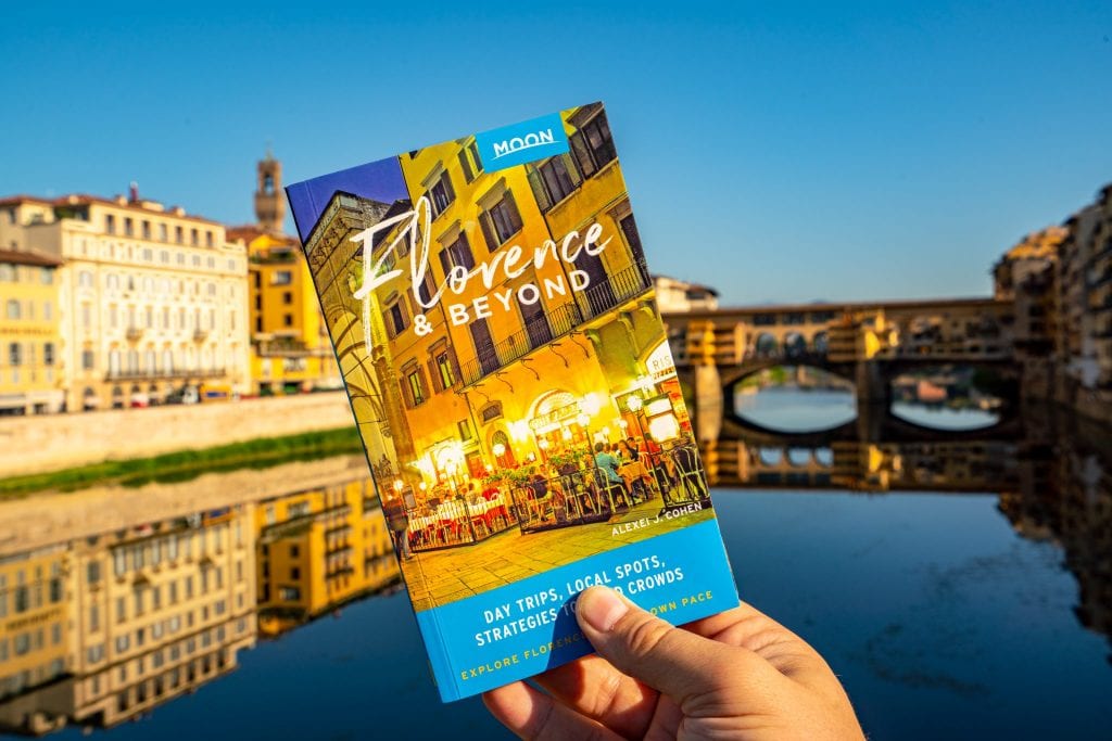 Photo of Moon Florence & Beyond being held up in front of the Ponte Vecchio