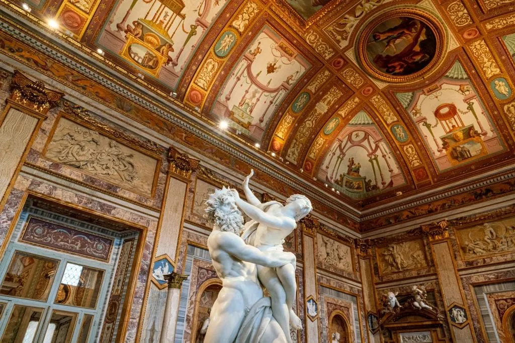 Interior of the Galleria Borghese in Rome, with a baroque statue in the center of the frame