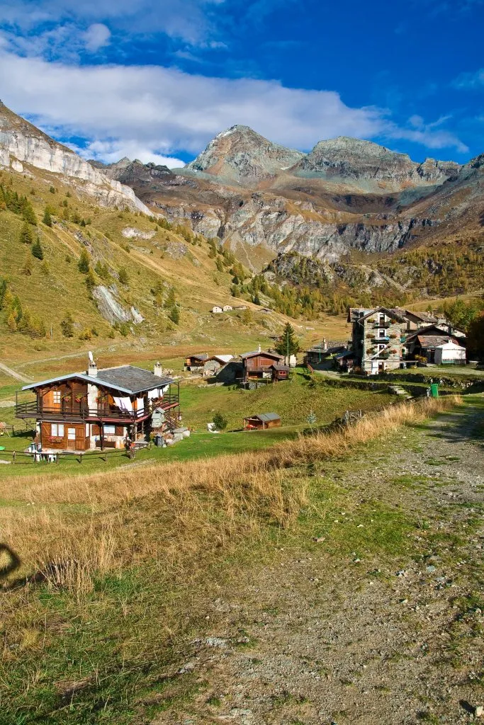view of alpine buildings in cheneil italy with dolomites in the background