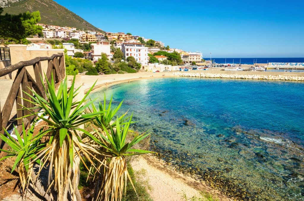 beach in Cala Gonone sardinia with village visible in the background
