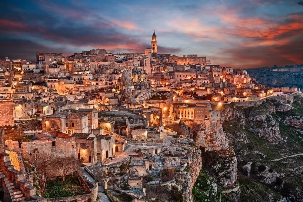 Matera at sunset with the lights in the city turned on, one of the prettiest small towns in Italy