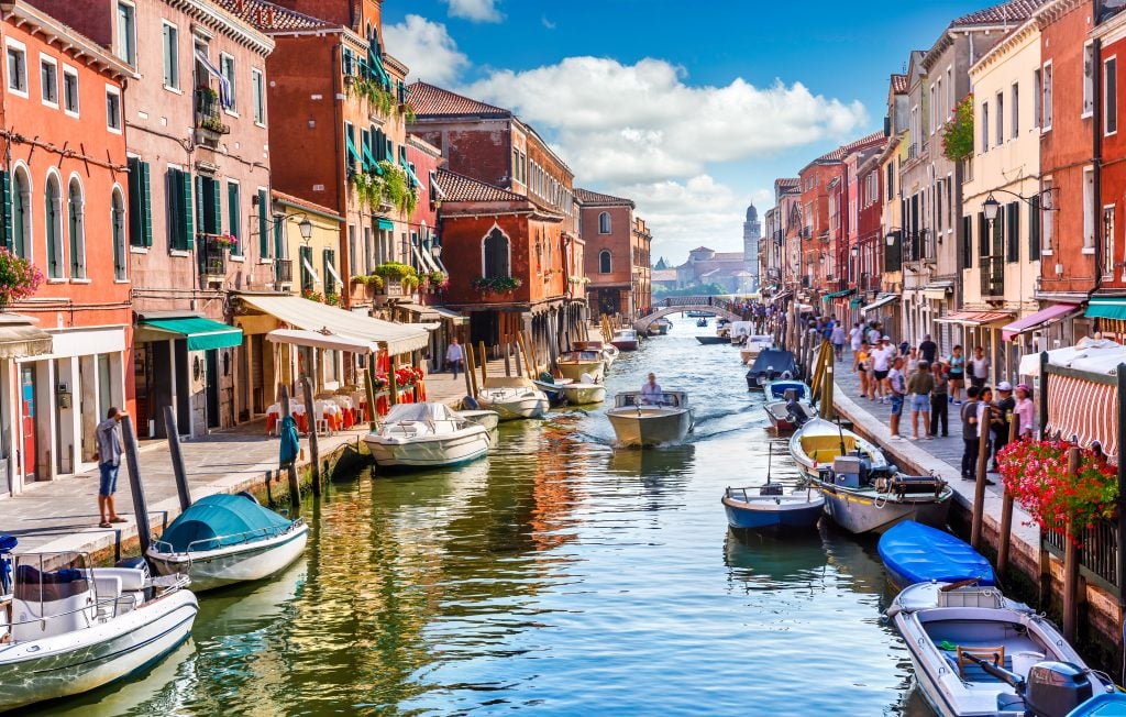colorful buildings lining a busy canal in murano italy